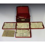 An early 20th century leather cased mah jong set with four removable trays containing one hundred