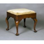 A George I walnut stool, the drop-in seat upholstered in green velour above a shaped frieze,