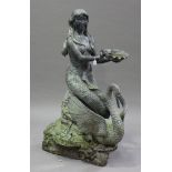A large 20th century patinated cast metal garden fountain in the form of a mermaid sitting on a