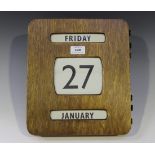 An early/mid-20th century stained beech wall mounted perpetual calendar with brass turning knobs,