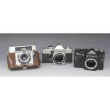 A collection of assorted camera bodies, including Praktica, Ricoh, Zenit, Minolta, Canon and