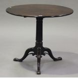 A George III mahogany tip-top supper table, the circular top above a turned stem, raised on carved