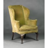 A Queen Anne wing back armchair, upholstered in green velour, the curved seat with loose cushion