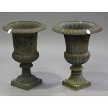 A pair of late 20th century cast iron garden urns of campana form, the reeded bodies raised on