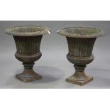 A large pair of late 20th century cast iron garden urns of campana form, the reeded bodies raised on