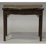 A George III figured mahogany serpentine-fronted fold-over card table, the hinged top above a