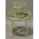 A late 20th century white painted wirework two-tier circular plant stand, raised on scroll legs,