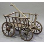 A 19th century wooden and wrought metal mounted hand cart fitted with four spoked wheels, height