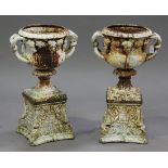 A pair of 20th century white painted cast iron garden urns, each shaped body decorated with trailing