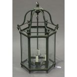 A large late 20th century green patinated cast metal hall lantern of hexagonal form, inset with