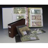 A collection of Greek banknotes, displayed in an album, and a collection of other banknotes of the