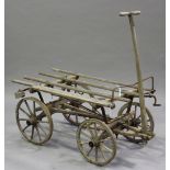 A 19th century pine and wrought iron mounted hay cart with braking mechanism and four spoked wheels,