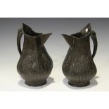 A pair of late 19th/early 20th century Far Eastern patinated copper jugs of angular baluster form,