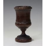 An 18th century turned yew goblet, the slightly waisted bowl raised on a spreading stem and