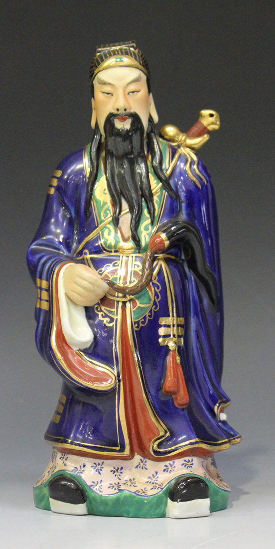 A Chinese porcelain figure of an immortal, 20th century, modelled standing wearing a blue robe