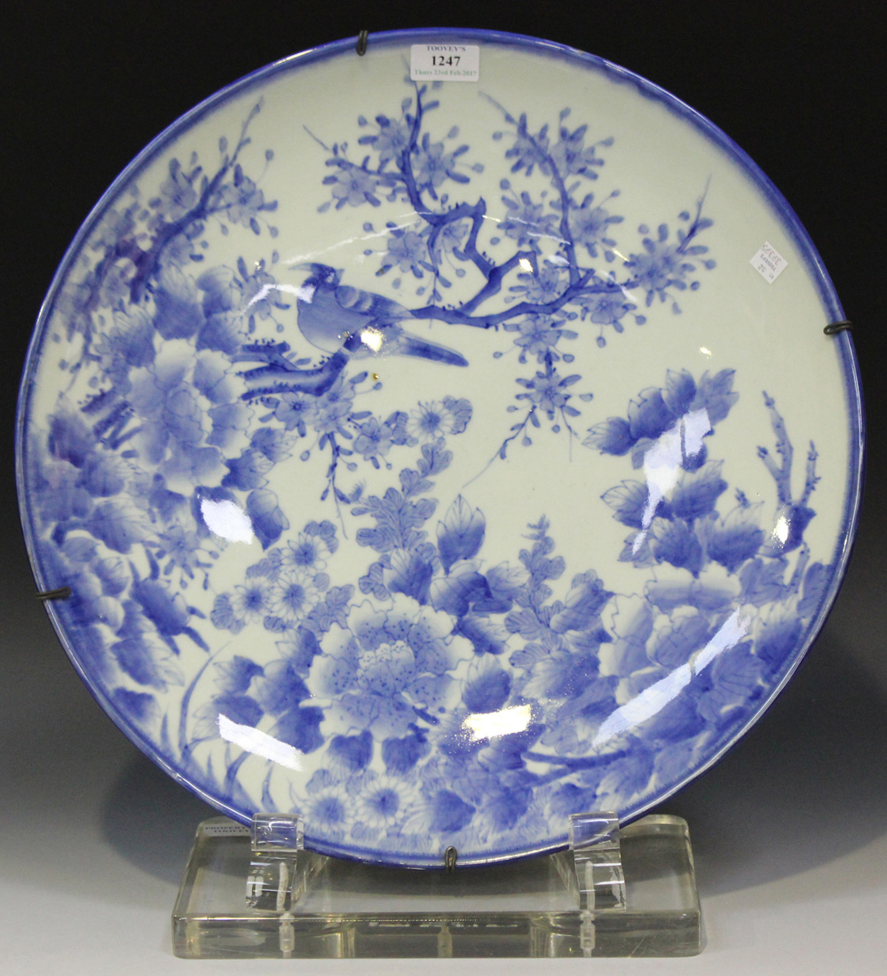 A Japanese Arita blue and white porcelain charger, Meiji period, painted with a bird amongst