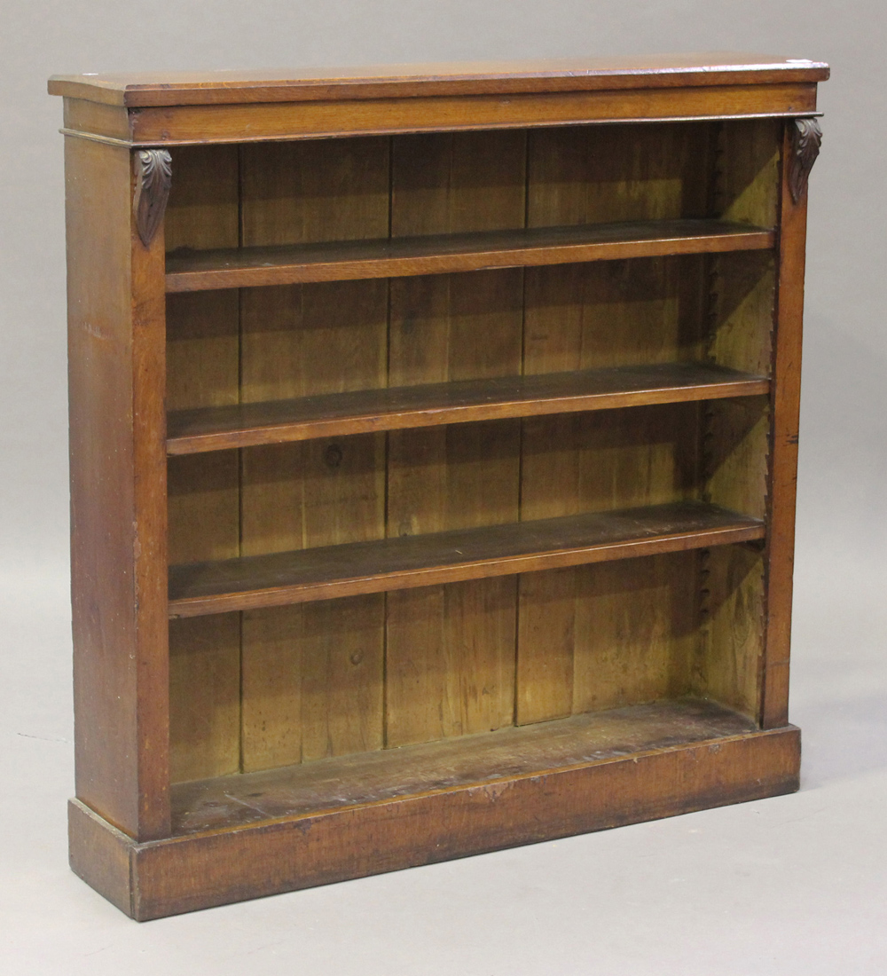 A late Victorian oak open bookcase, fitted with three adjustable shelves, raised on a plinth base,