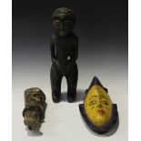 An African carved wood full-length figure, height 51cm, together with a polychrome painted mask