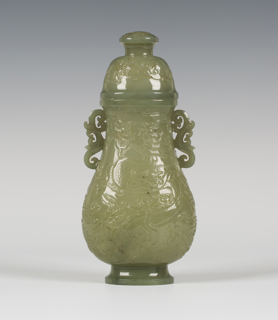 A Chinese celadon jade pear form vase and cover, late Qing dynasty, finely hollowed and carved in