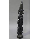 An African carved hardwood fertility figure of a full-length female nude, height 122cm.