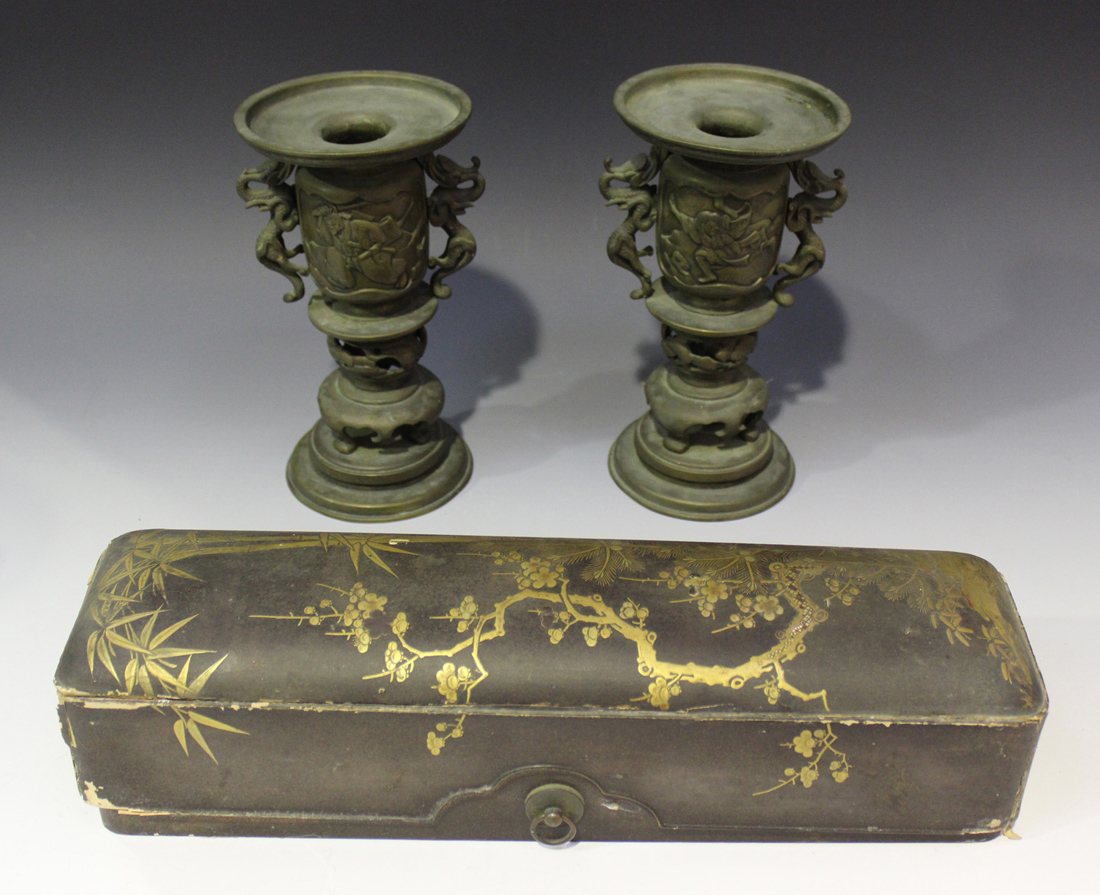 A pair of Japanese bronze incense burners, Meiji period, each pan top above cast figural panels,