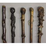 A group of five various walking sticks, including a Japanese carved bamboo stick, an African