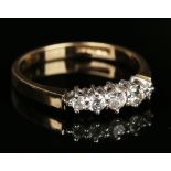 A 9ct gold and diamond five stone ring, claw set with a row of graduated circular cut diamonds,
