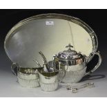 A plated three-piece tea set of half reeded form, comprising teapot, two-handled sugar bowl and milk