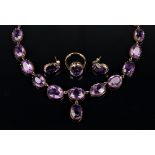 A Victorian gold and amethyst collar necklace, mounted with a row of graduated oval cut amethysts,