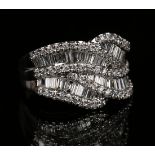 An 18ct white gold and diamond ring in an undulating design, mounted with baguette cut diamonds,