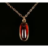 A gold and carbuncle garnet single stone pendant with a gold neckchain and a matching pair of