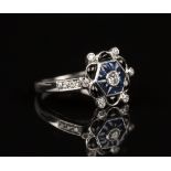 An 18ct white gold, diamond, sapphire and onyx ring of stylized flowerhead form, the central