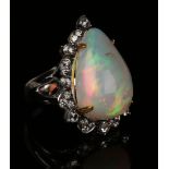 An 18ct white gold, opal and diamond ring, claw set with a large pear shaped opal within a shaped