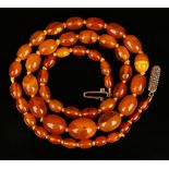 A single row necklace of forty-eight graduated oval vari-coloured semi-translucent butterscotch