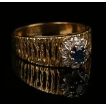 An 18ct gold, sapphire and diamond oval cluster ring, claw set with the oval cut sapphire within a