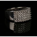 A 9ct white gold and diamond set ring in a curved panel shaped design, mounted with five rows of
