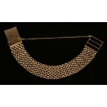 A 9ct gold bracelet in a wide woven mesh link design, on a fold-over clasp, London 1965, length