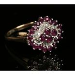 A 9ct gold, ruby and diamond cluster ring, mounted with the principal four circular cut rubies