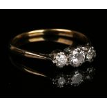 A gold, platinum and diamond three stone ring, claw set with circular cut diamonds with the