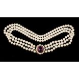 A three row collar necklace of uniform cultured pearls on a gold, cabochon amethyst and cultured