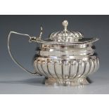 A George III silver mustard of half reeded circular form, the hinged lid with domed reeded centre