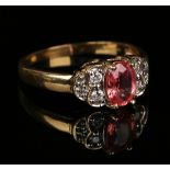 An 18ct gold, diamond and pink gem stone ring, claw set with the oval cut pink gem stone between