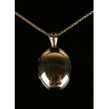 A gold oval plain pendant locket with a 9ct gold circular link neckchain on a boltring clasp.