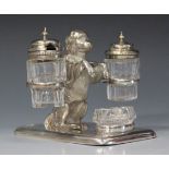 A Victorian plated novelty cruet set in the form of a begging dog, fitted with a cut glass pepper