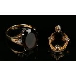 A 9ct gold ring, claw set with an oval cut smoky quartz between diamond single stone shoulders, ring