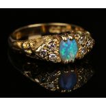 An 18ct gold, opal and diamond ring, mounted with an oval opal between circular cut diamond set