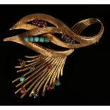 A gold, ruby, sapphire and turquoise brooch, designed as a scrolling spray, with a partly textured