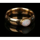 A gold band ring, collet set with an oval opal, unmarked, ring size approx M. Buyer’s Premium 29.