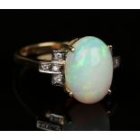An 18ct gold, opal and diamond ring, claw set with the oval opal between diamond set four stone