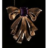 A gold, amethyst and baguette diamond brooch, designed as a tied ribbon bow with pierced decoration,